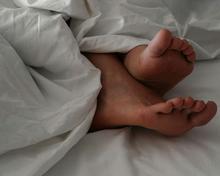 Nakte Füße unter einer Decke