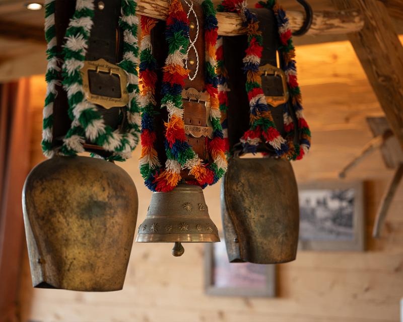 Bunte allgäuer Schellen, die in der Stube auf einer Stange hängen